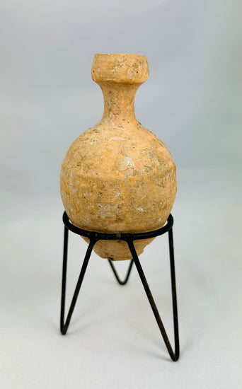 Roman cosmetic and bathing oil bottle with earthen deposits and aged surface