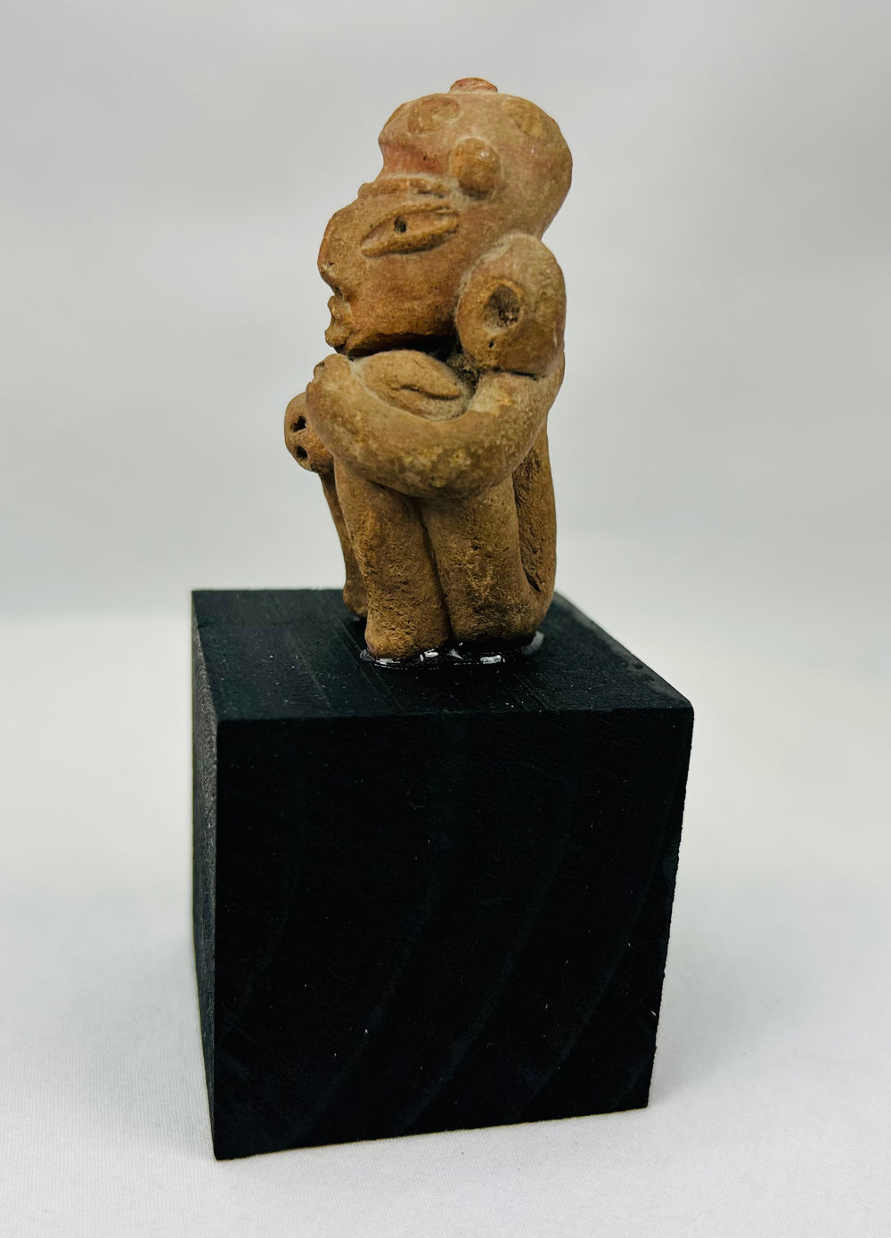 Expressive Pre-Columbian terracotta ancestor figure with stylized facial features and ear ornaments
