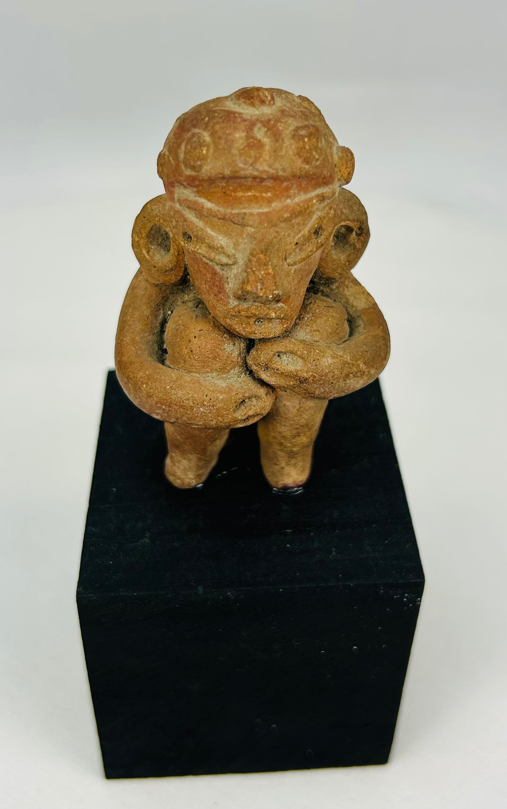 Ancient Mesoamerican terracotta figure with ritual seated pose and subtle traces of original pigment
