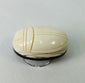 Side view of antique East Asian scarab talisman highlighting smooth polished surface