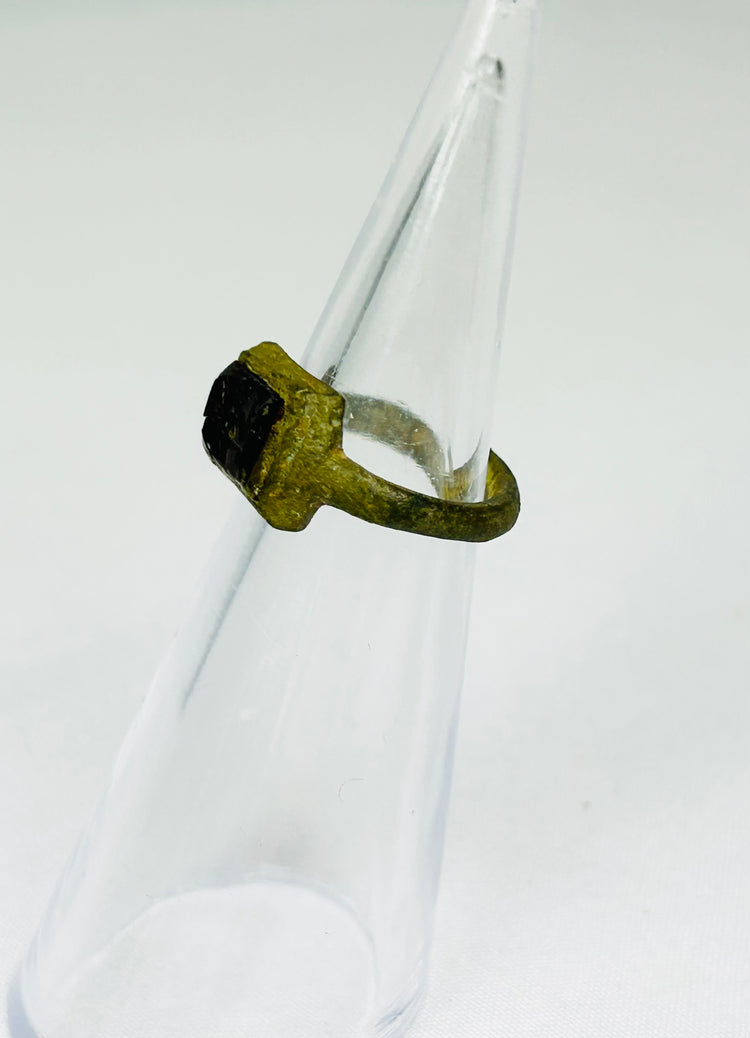 Historic Roman jewelry artifact displayed on museum-style black presentation stand