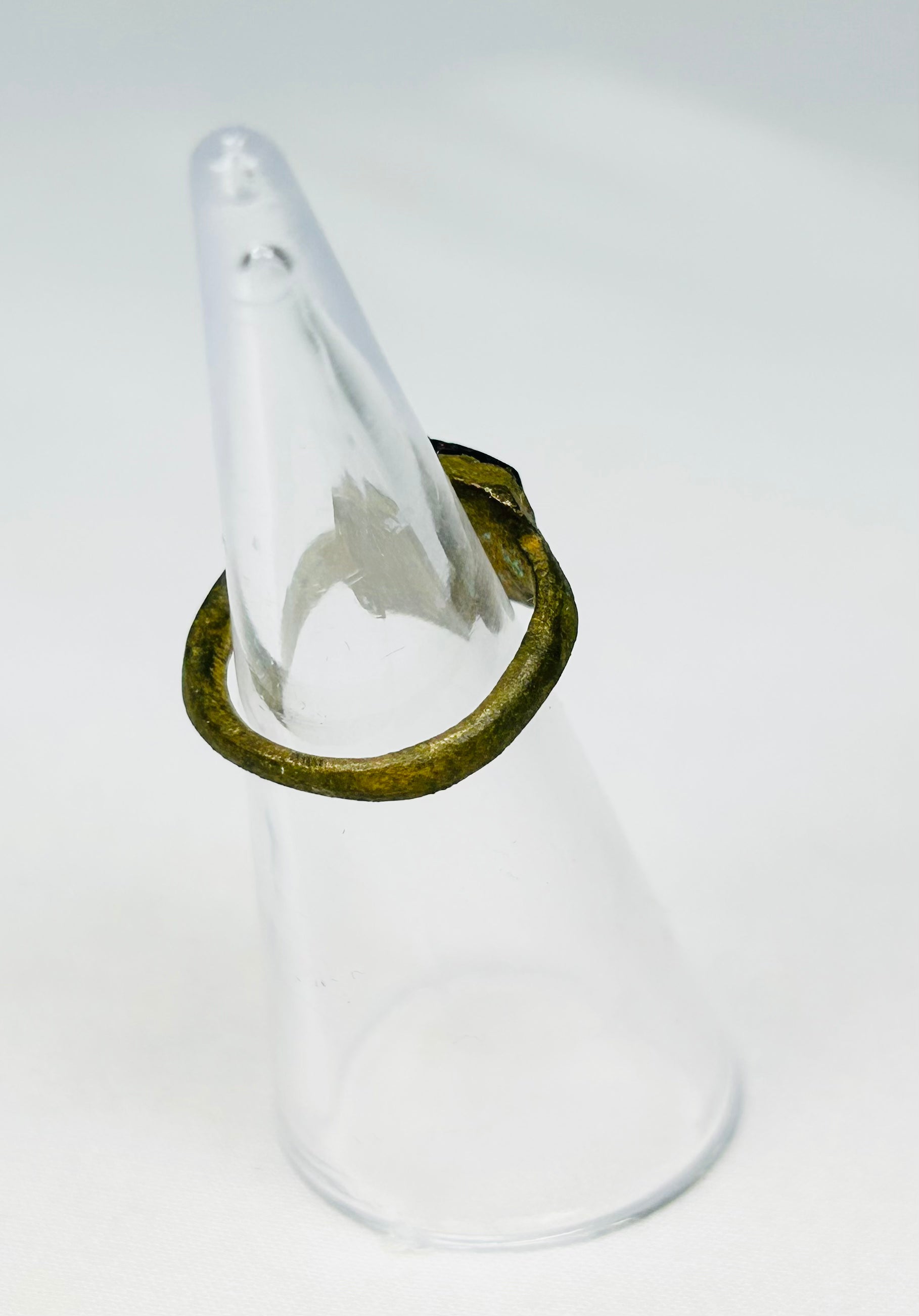 Archaeological Roman bronze ring relic photographed against neutral background