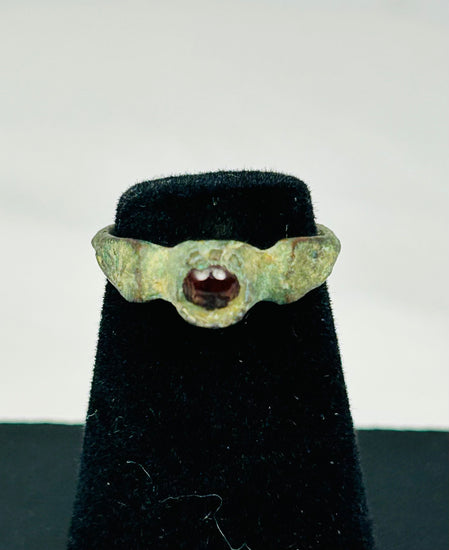 Close-up of 2nd-century Roman bronze ring showing polished red garnet and aged patina