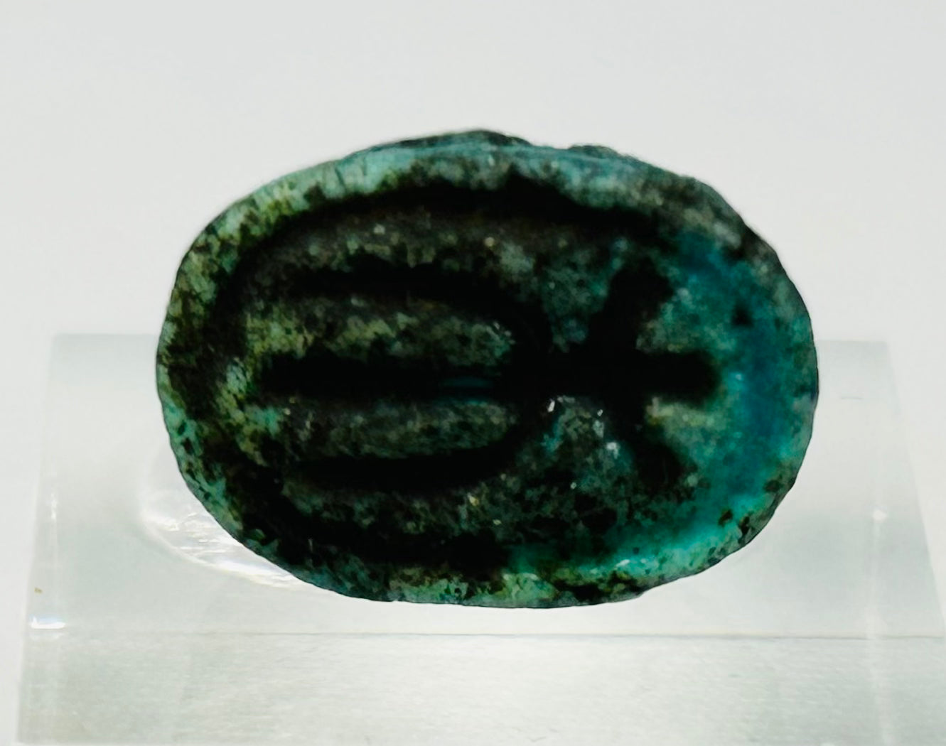 Underside of Egyptian scarab amulet showing impressed symbolic markings