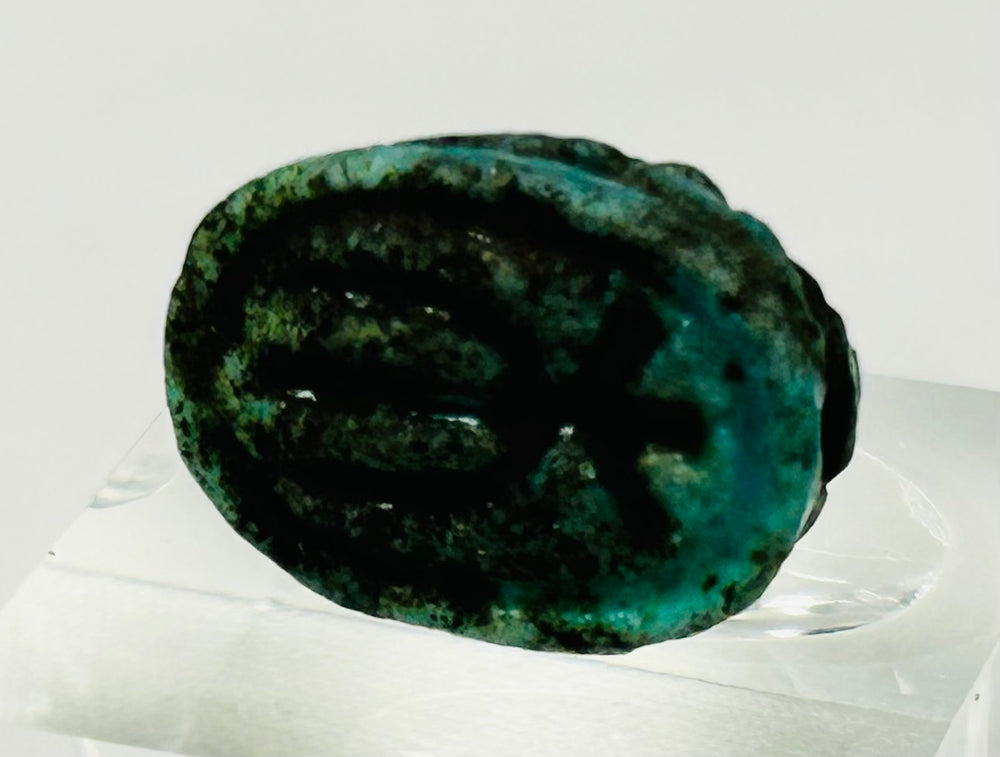 Bottom view of Egyptian scarab amulet showing impressed symbolic markings