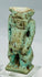 Close-up of Egyptian faience Bes deity amulet showing muscular torso and powerful stance