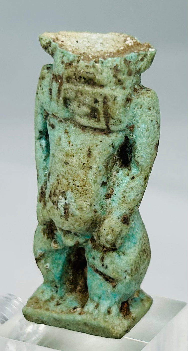 Close-up of Egyptian faience Bes deity amulet showing muscular torso and powerful stance