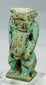 Close-up of Egyptian faience Bes deity amulet showing muscular torso and powerful stance