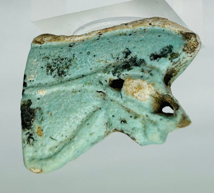 Blue faience Eye of Horus amulet fragment with visible ancient surface textures