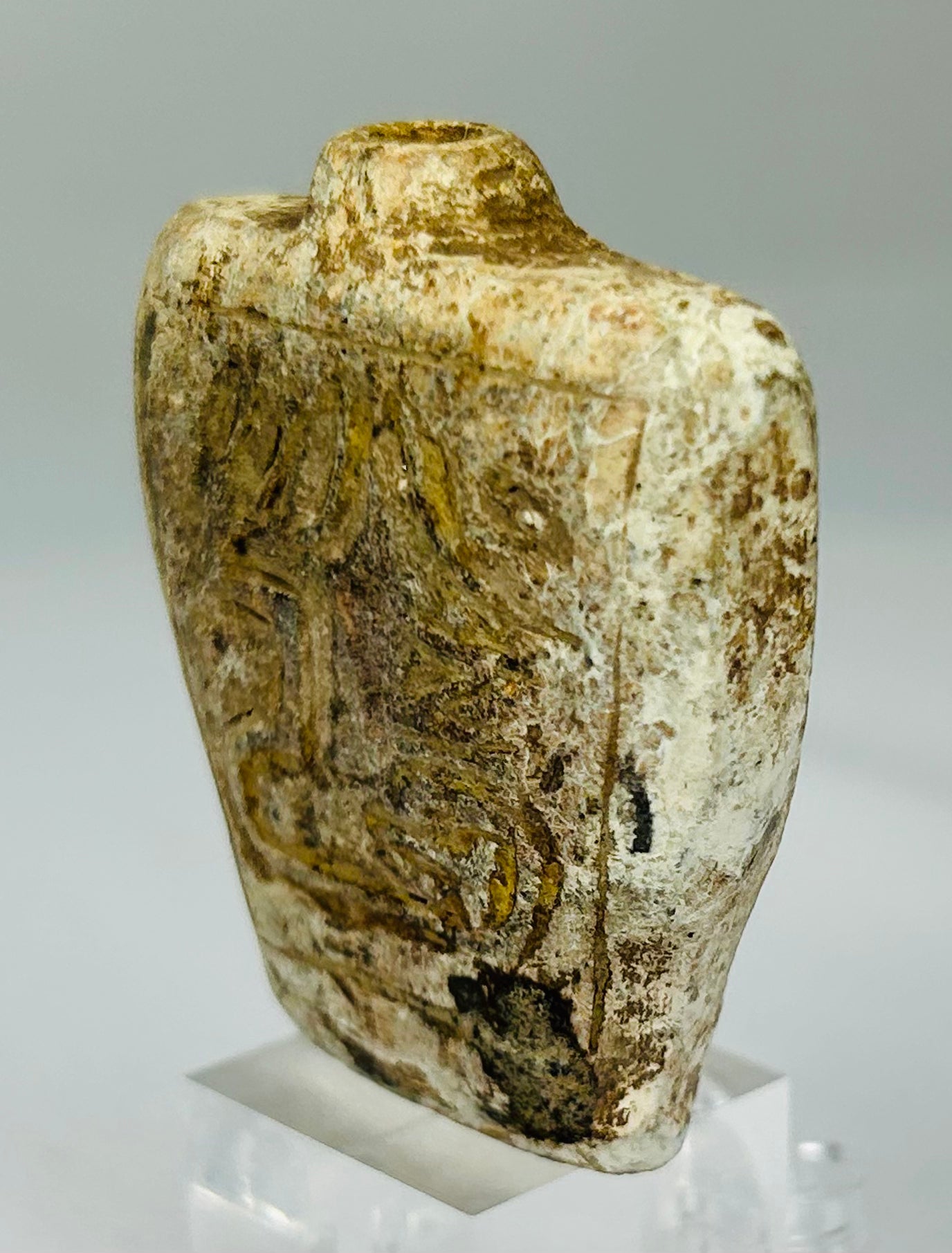 Double-sided carved stone amulet vessel with protective symbolic decoration