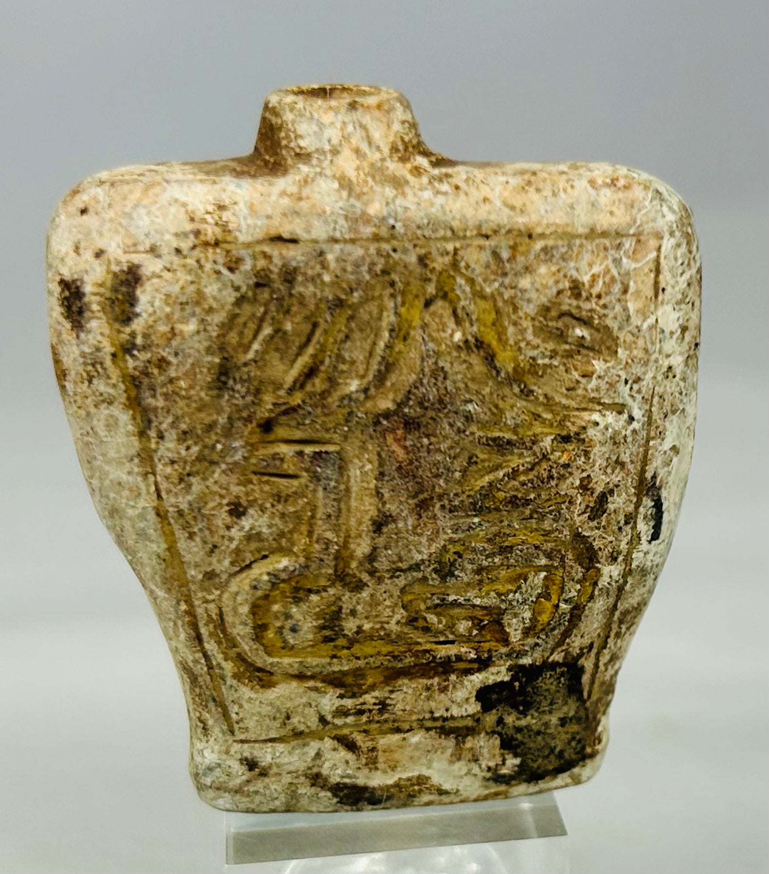 Ancient stone container amulet likely used for oil or pigment with decorative carvings