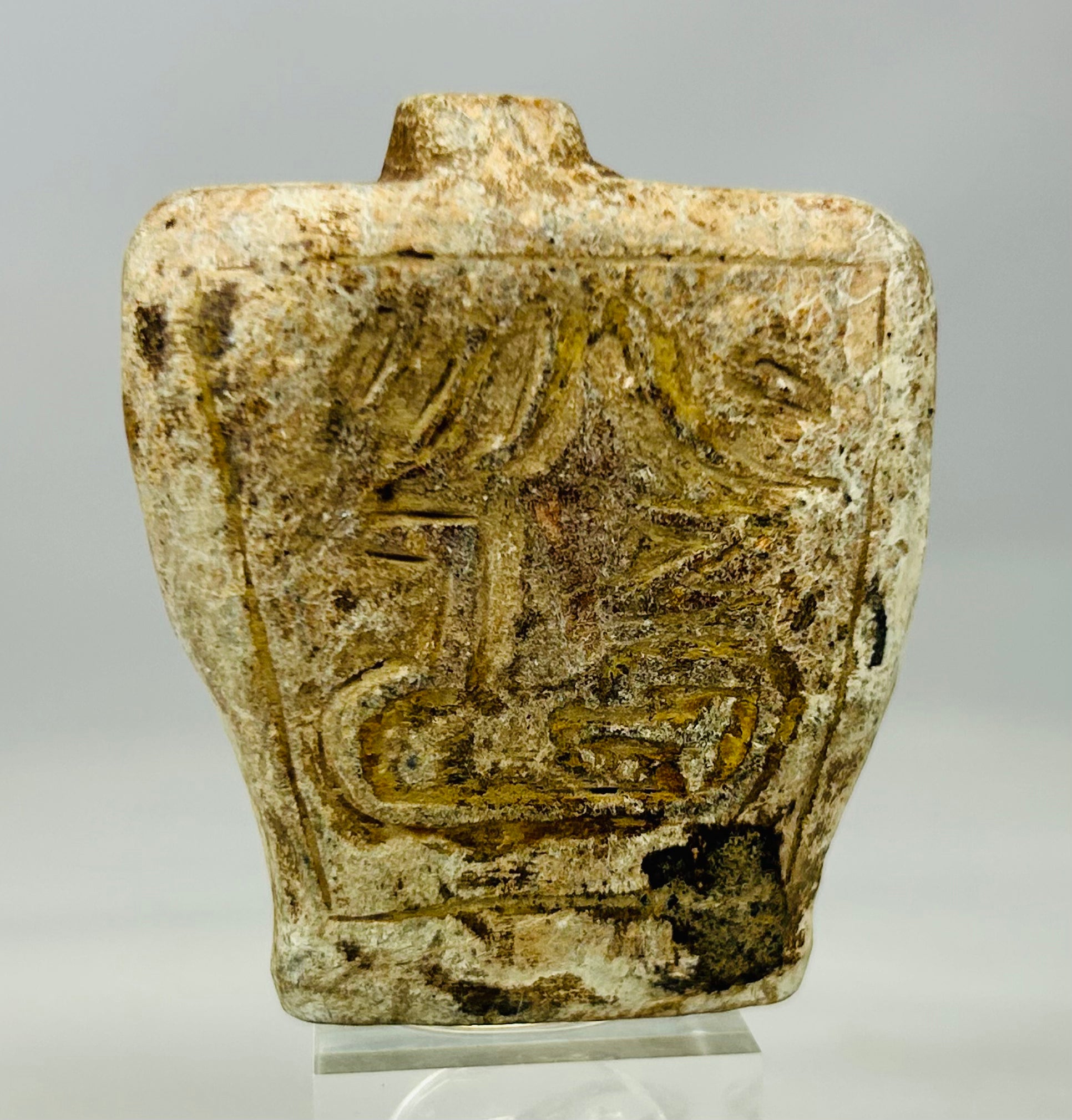 Ancient Eastern Mediterranean stone flask amulet showing animal relief and abstract motif