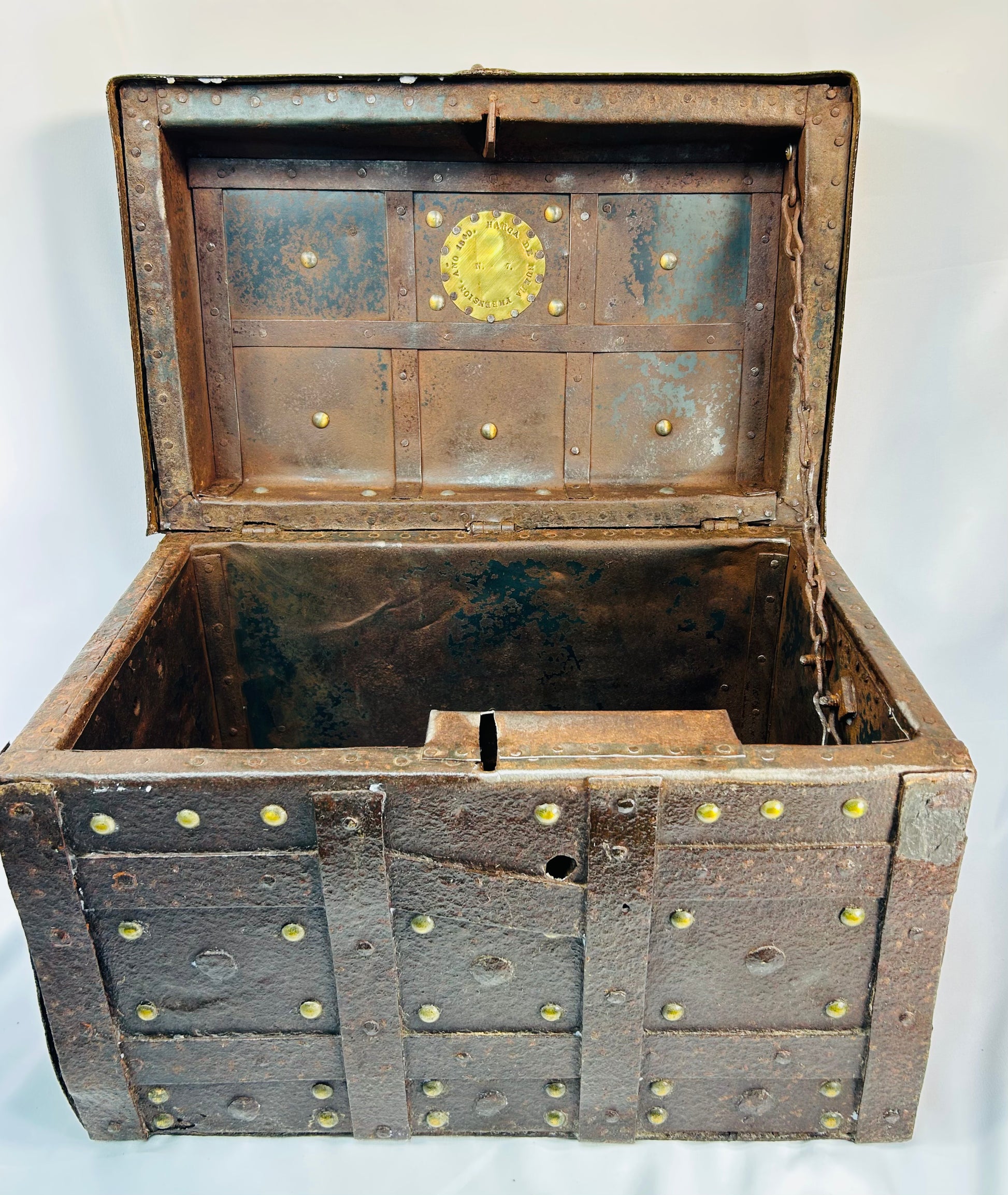 Heavy wrought-iron strongbox with brass plaque reading “Año 1840,” decorative studs, and signs of extensive working life use