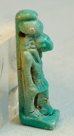 Ancient Egyptian protective faience amulet of Horus with mineral deposits and glaze wear