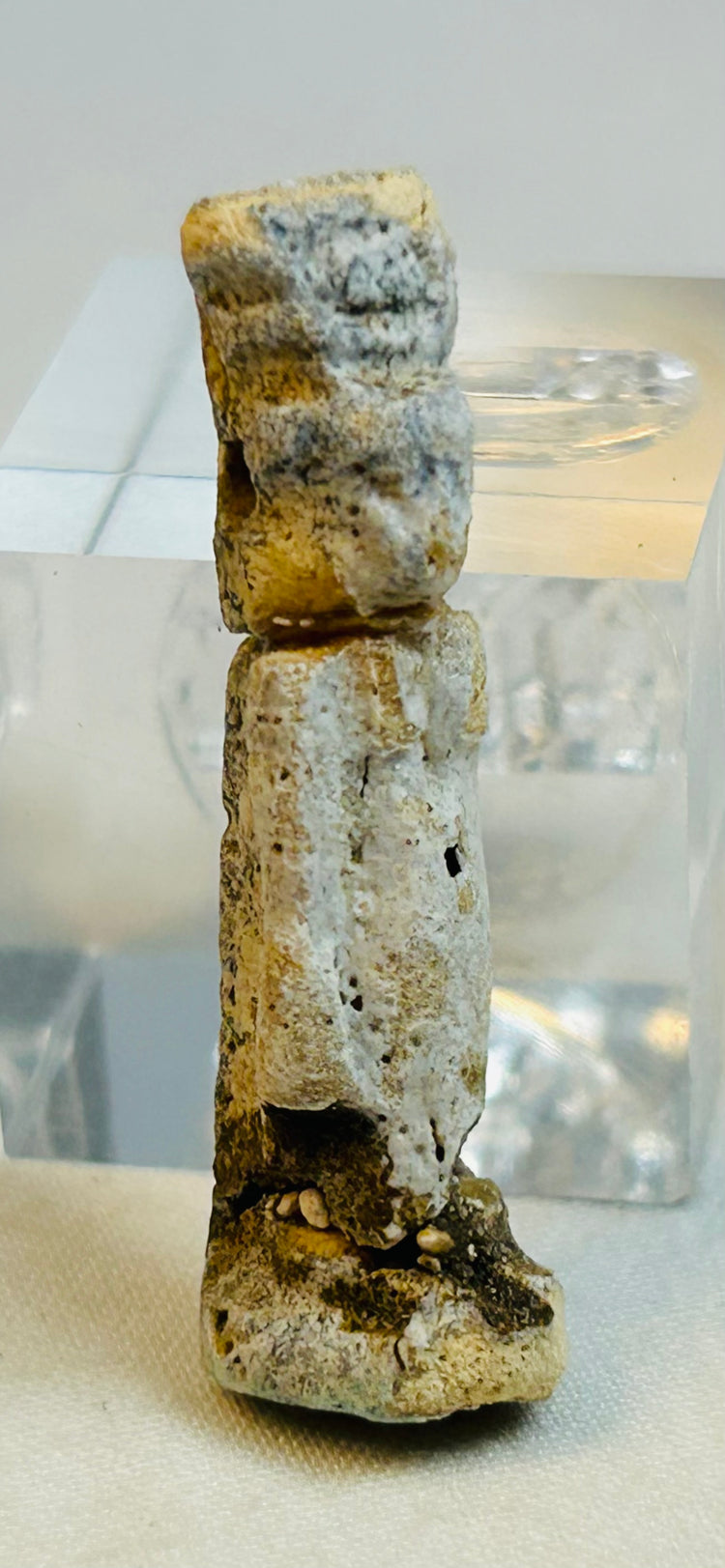 Late Period to Ptolemaic Egyptian faience figure with calcified deposits photographed front facing.