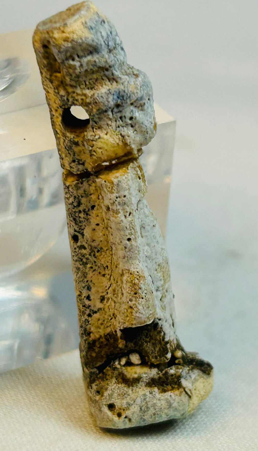 Small ancient Egyptian amulet figure covered in desert patina and burial encrustation.