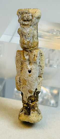 Detail shot of torso and legs of Egyptian Late Period faience figure with patinated surface.