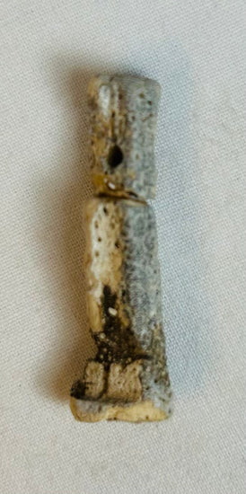 Heavily patinated Egyptian faience amulet displayed standing, circa 664–30 BCE.