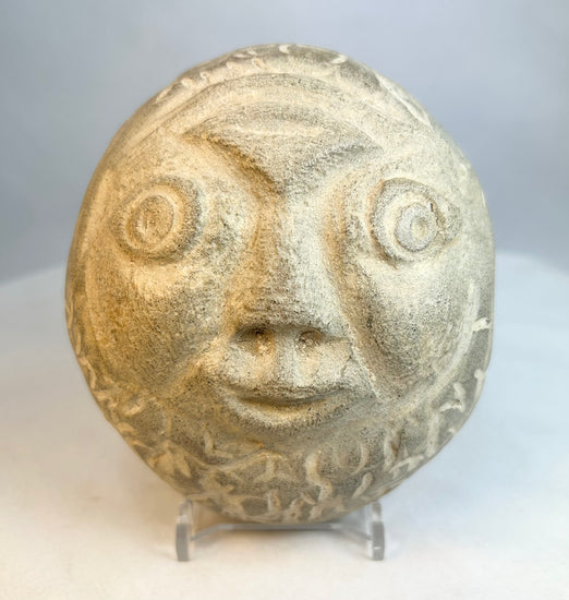 Close-up of carved stone face highlighting textured surface and facial features