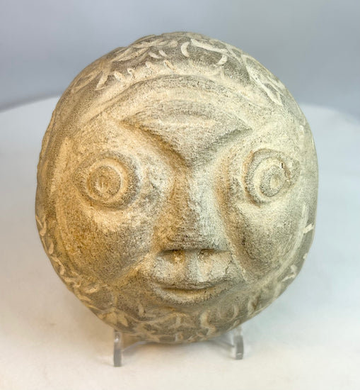 Primitive-style carved stone head showing natural stone coloration and aging