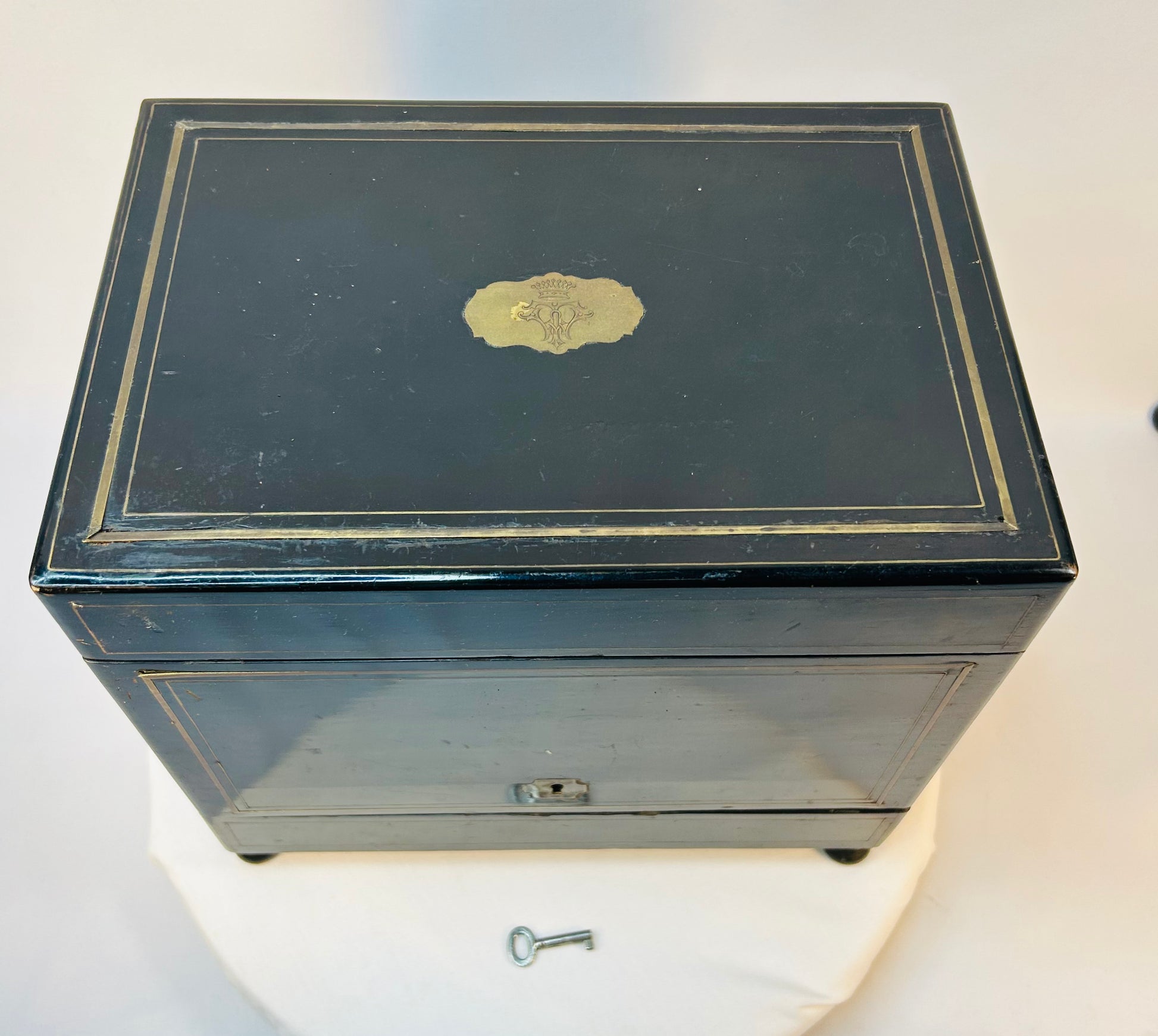 Antique ebonized medical cabinet with brass inlay and crowned crest plaque on the lid