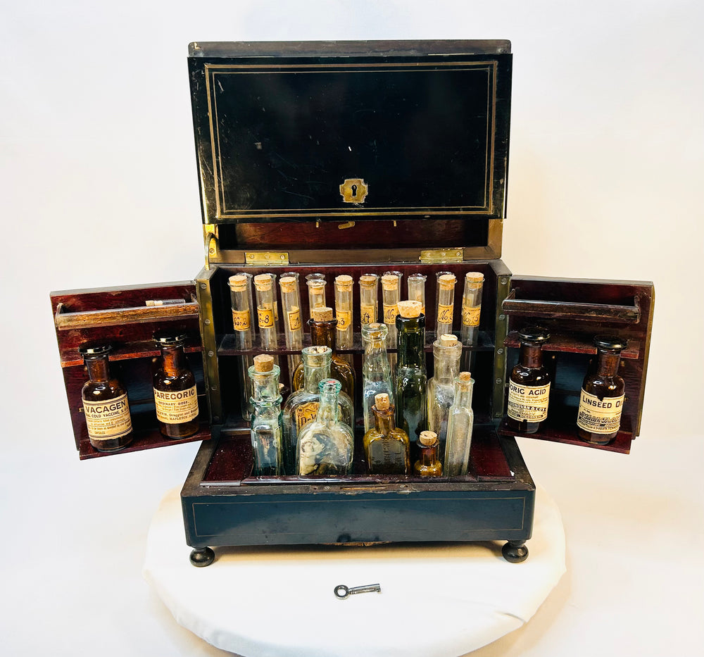 Interior of Victorian apothecary chest showing organized glass bottles with original corks