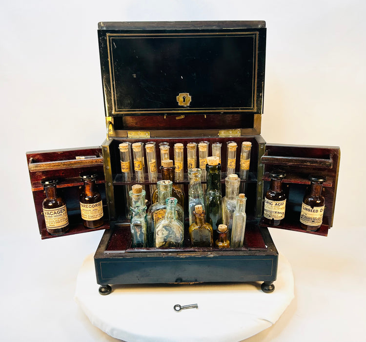 Interior of Victorian apothecary chest showing organized glass bottles with original corks