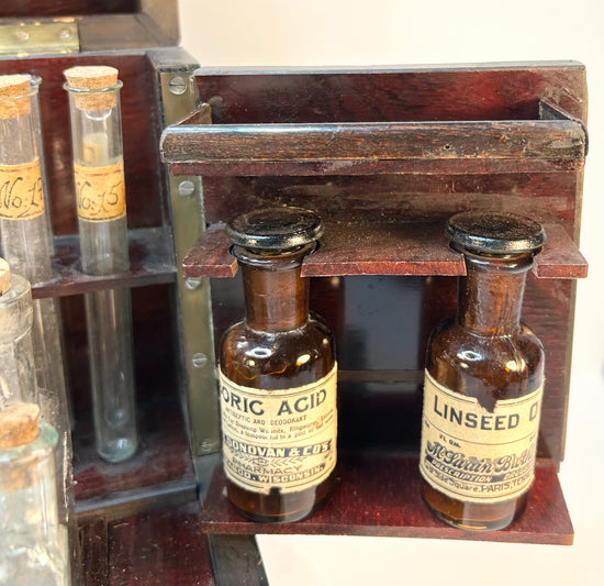 Close-up of Victorian apothecary bottles with paper labels and aged patina