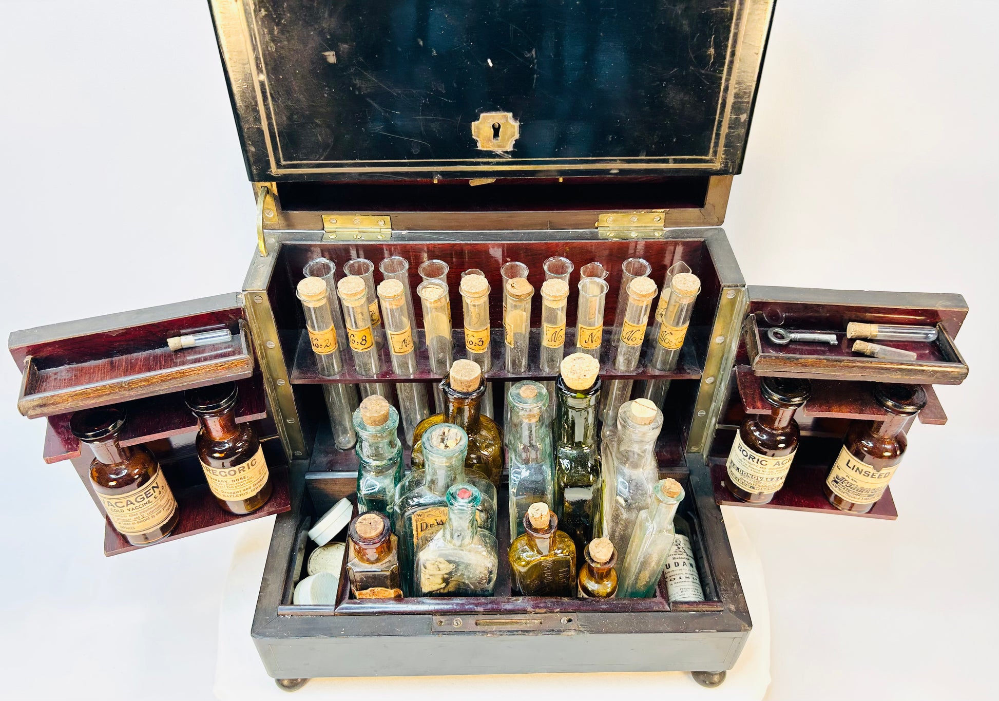 Complete display of apothecary chest contents arranged in front of cabinet
