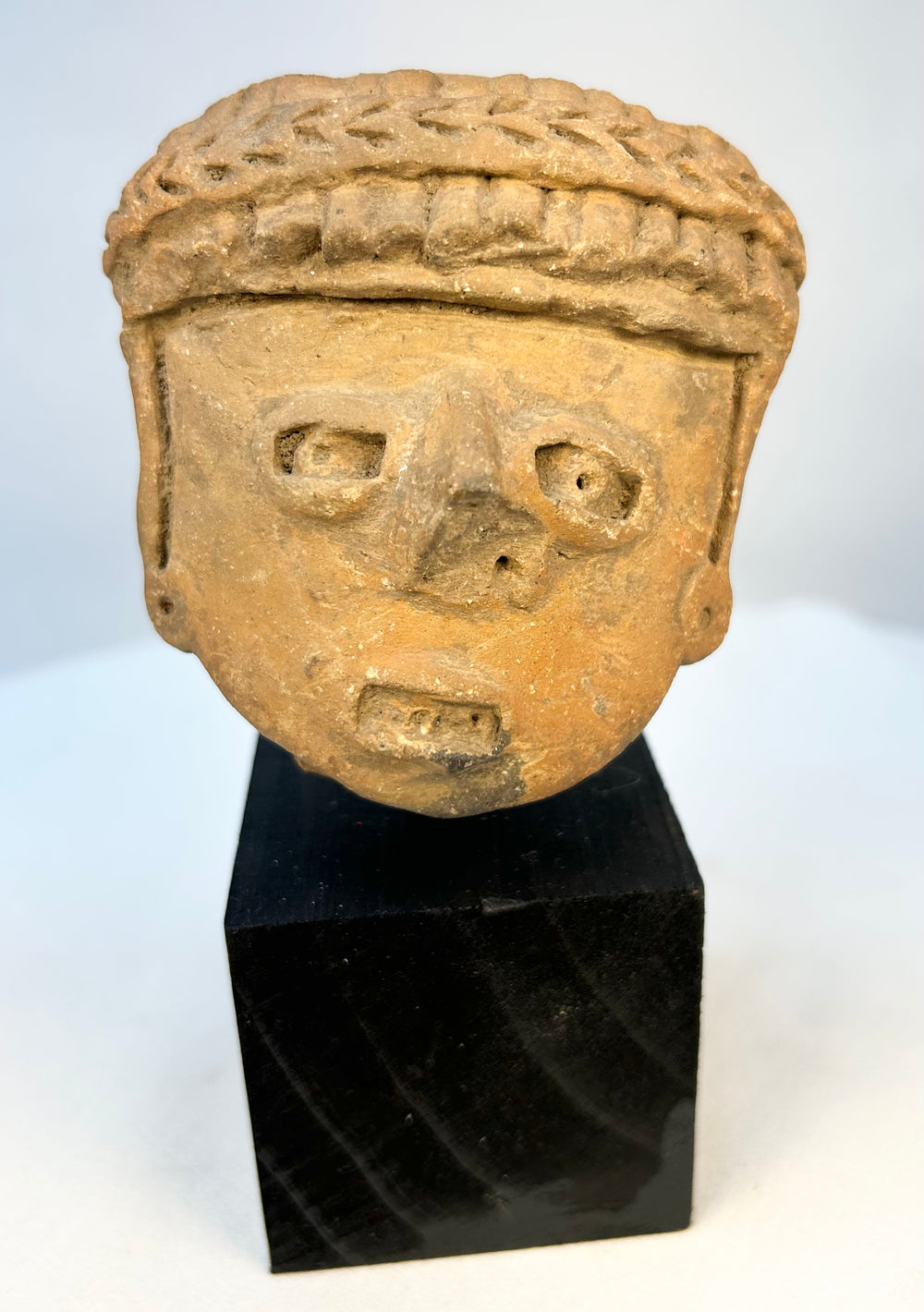 Ancient Mesoamerican terracotta portrait head with braided headdress
