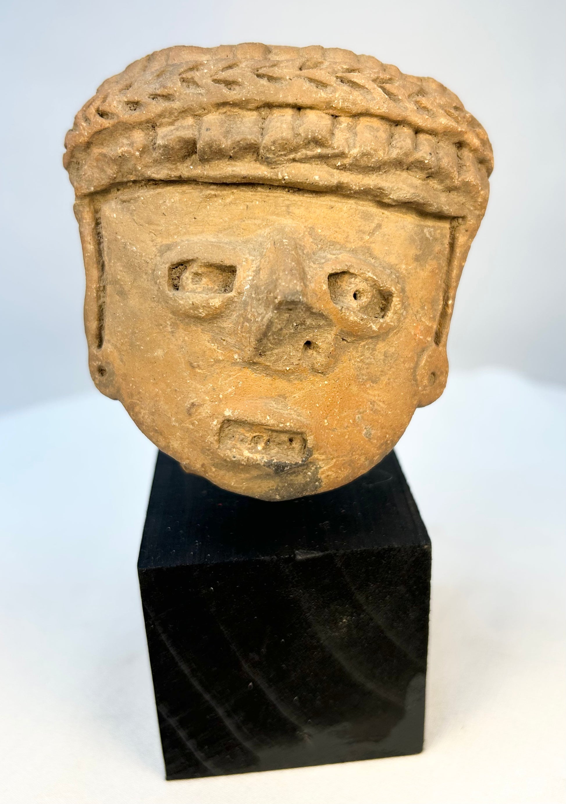 Ancient Mesoamerican terracotta portrait head with braided headdress