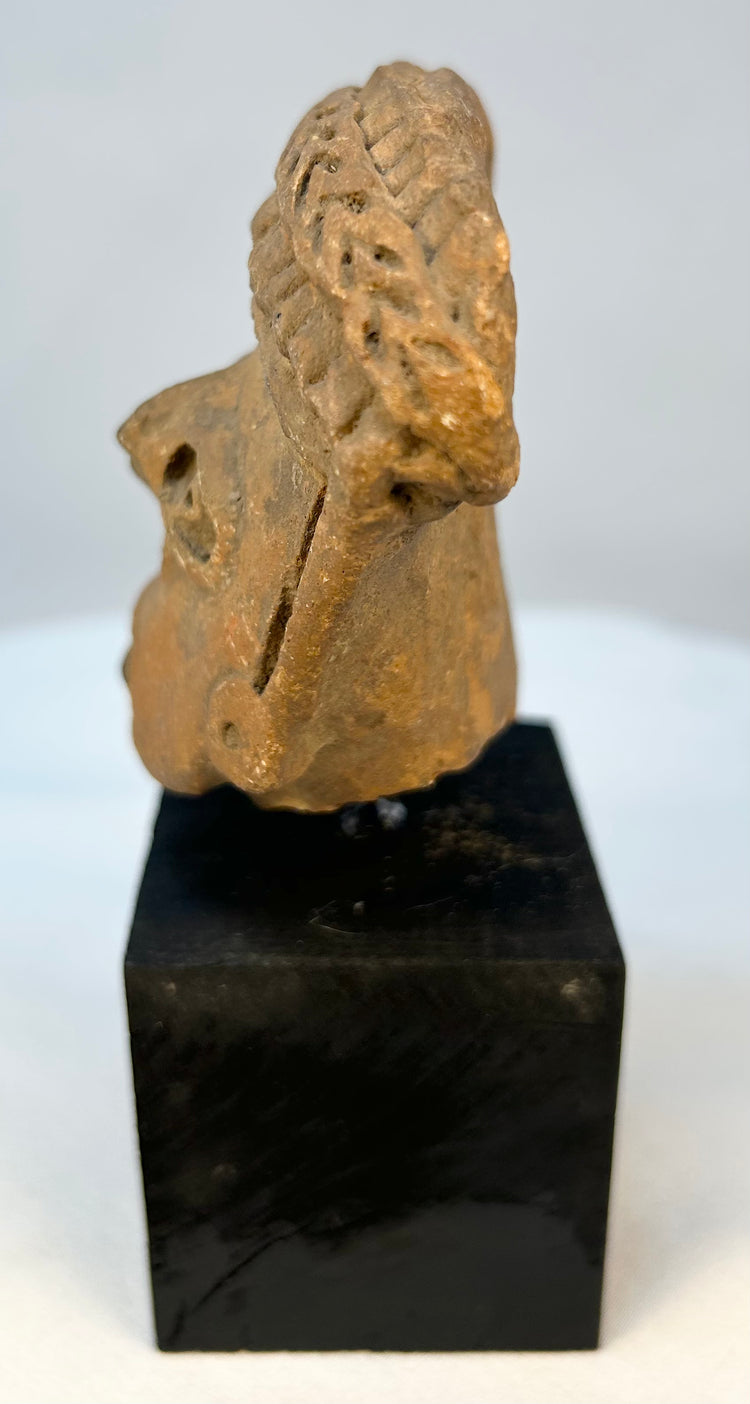 Ancient Mesoamerican terracotta sculpture fragment mounted for display