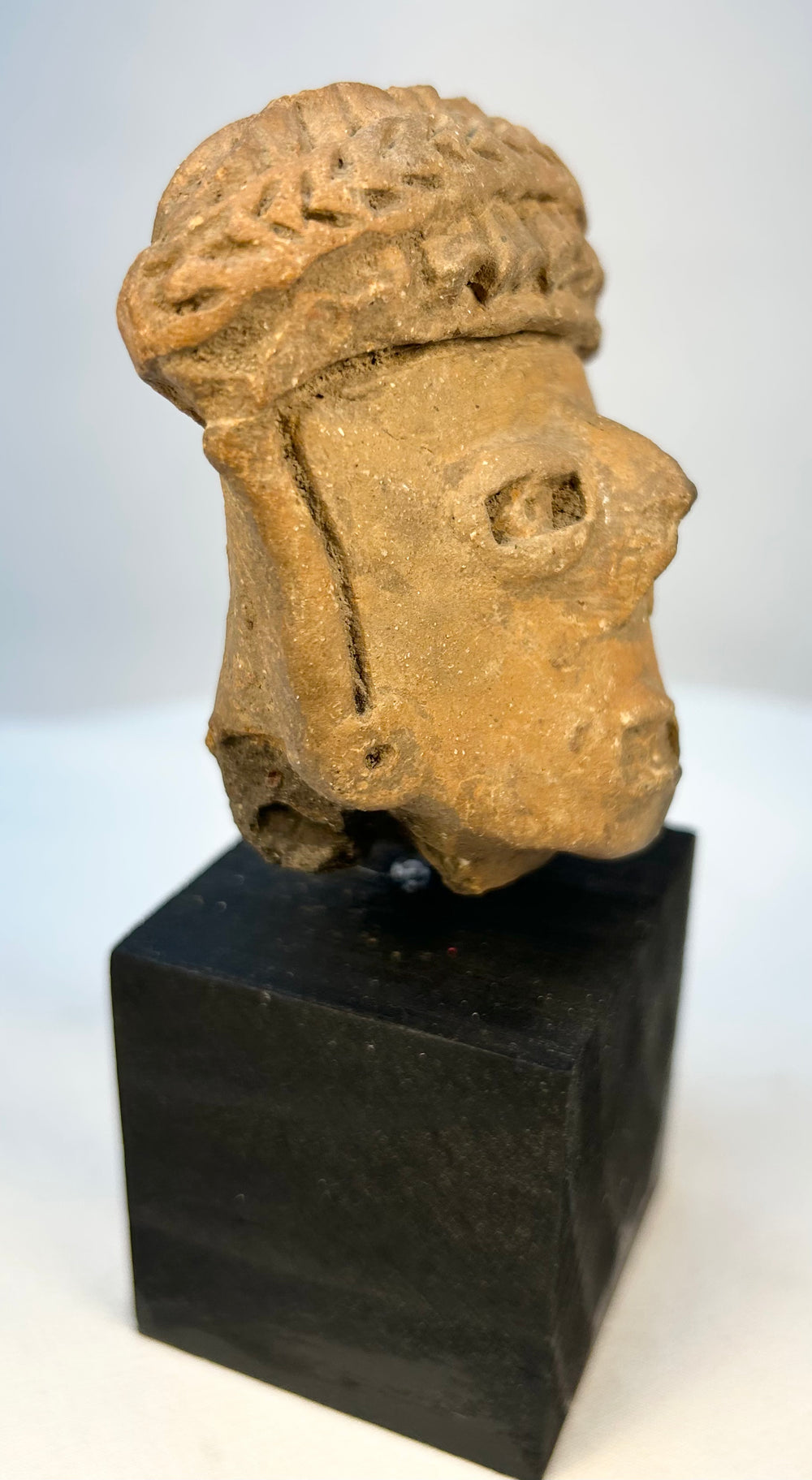 Pre-Columbian clay portrait head with carved facial features and headdress