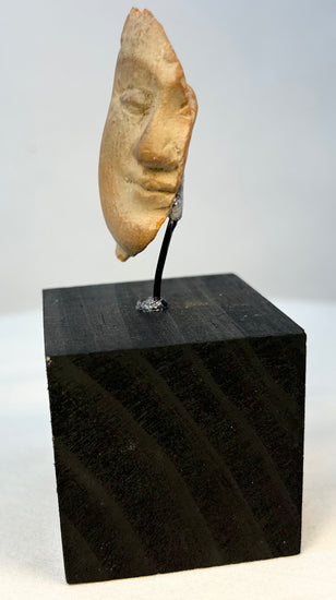 Close-up of antique terracotta face fragment showing age and patina