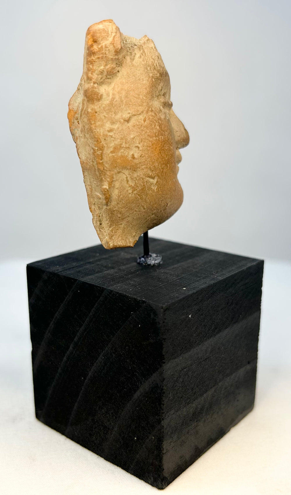 Profile view of ancient terracotta face with strong chin and nose