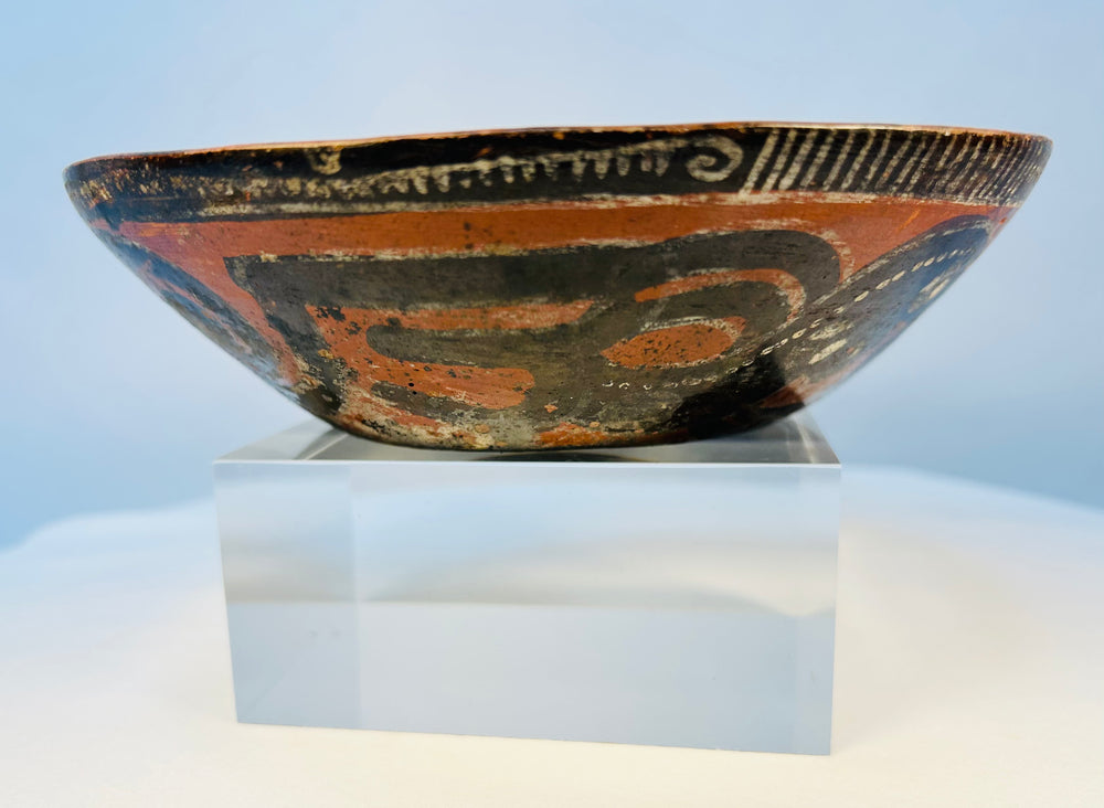 Ancient ceramic bowl with black-and-white painted decoration over orange clay body