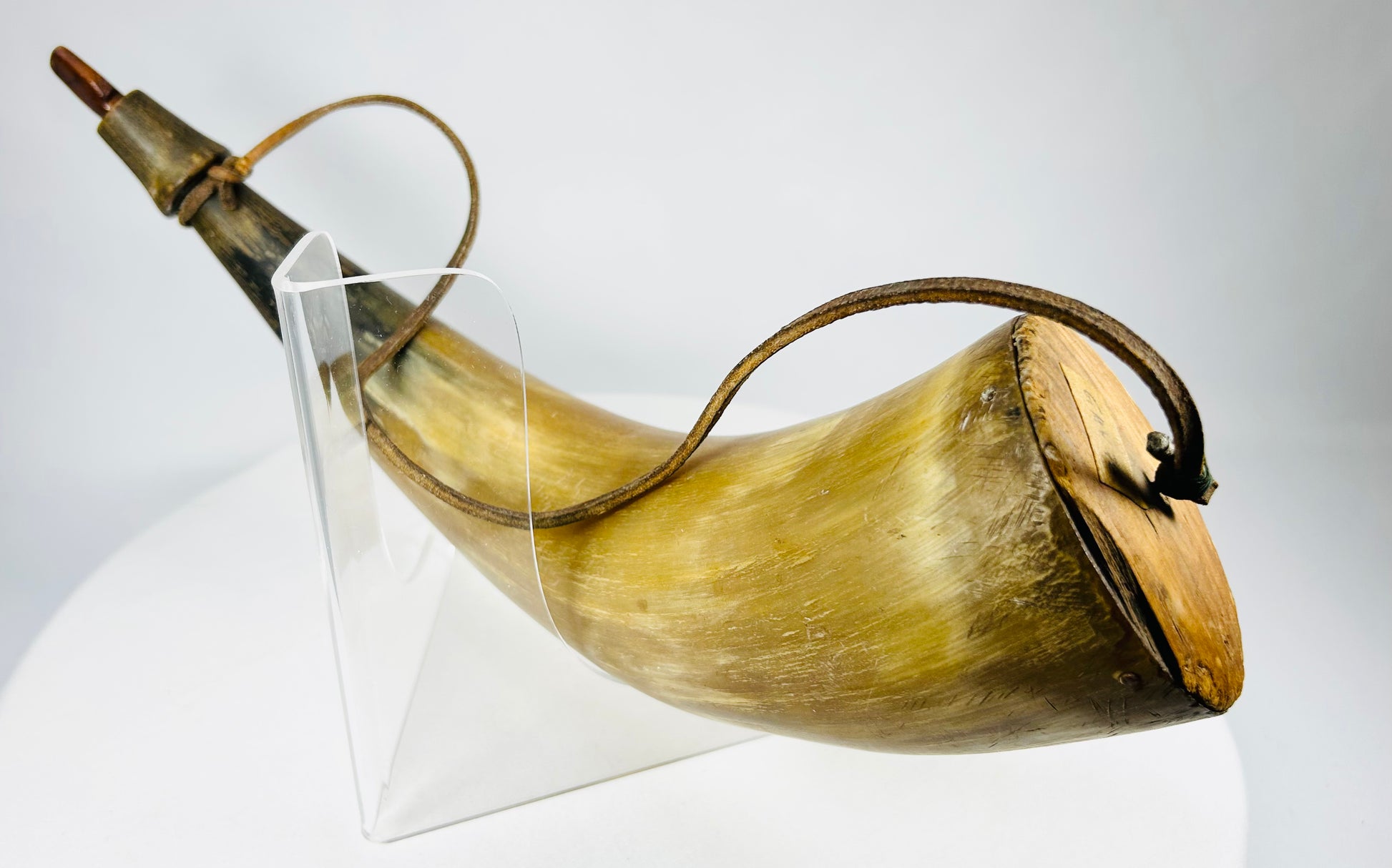 Antique 19th-century powder horn used by hunters and soldiers, featuring leather strap and wood plug