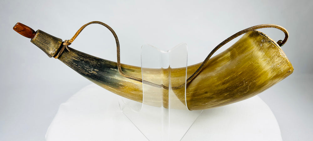 Historical North American black powder horn with tapered form, aged surface, and preserved hardware