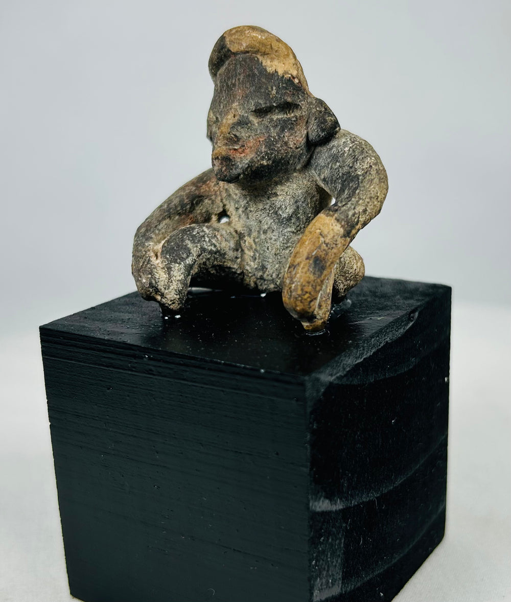 Museum-quality Pre-Columbian seated terracotta figure displaying mineral deposits and ancient surface wear