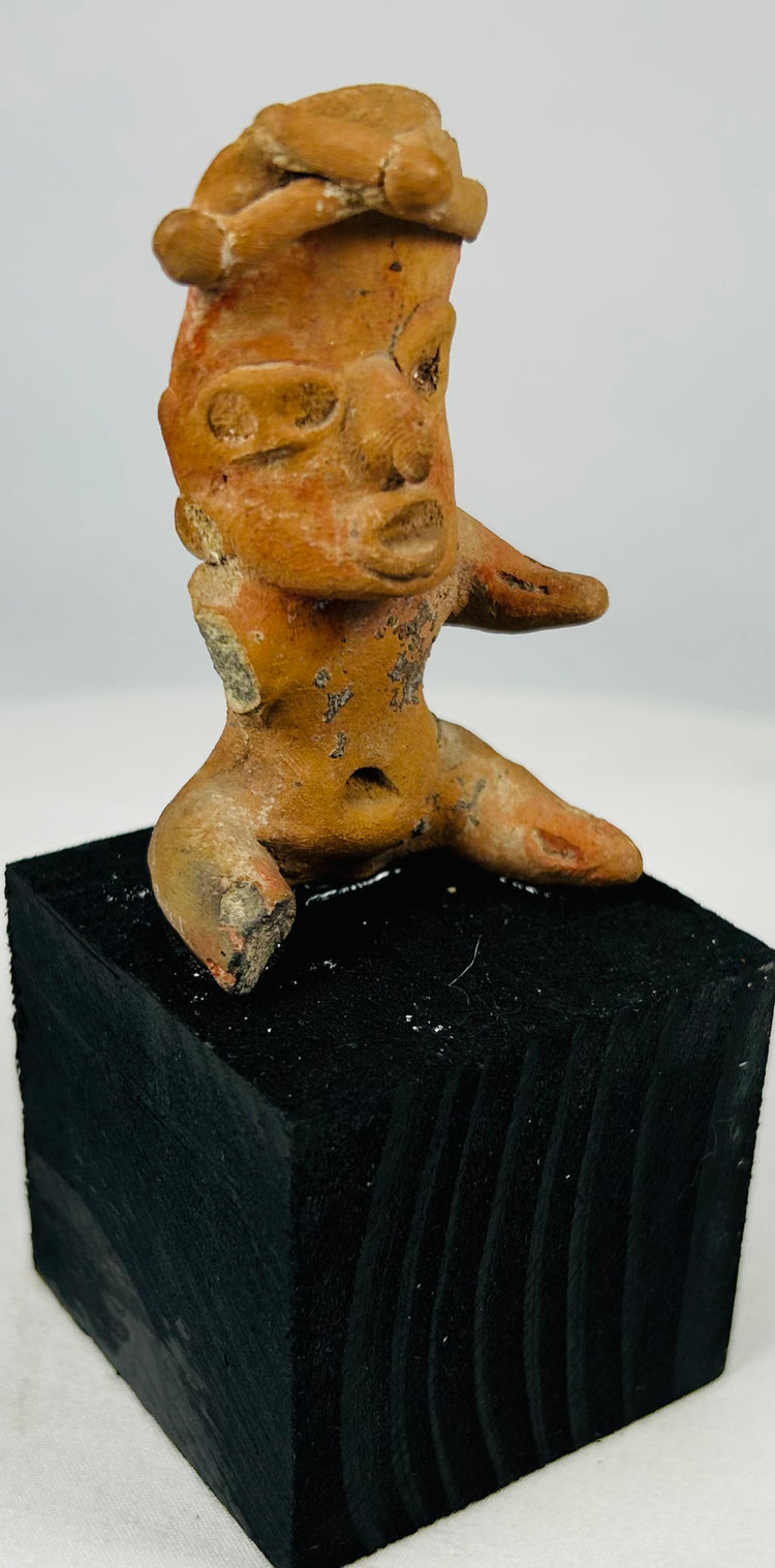Ancient Pre-Columbian terracotta effigy sculpture with seated posture, ear ornaments, and ceremonial heritage