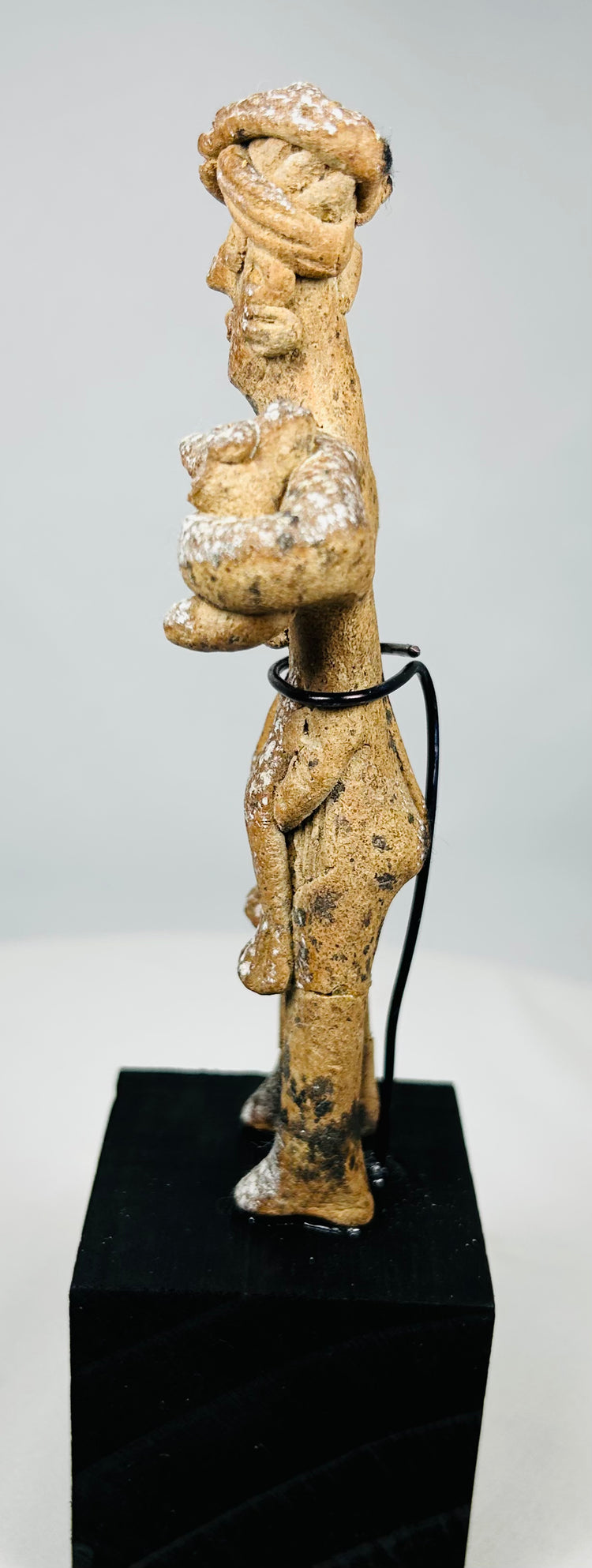 Ancient Pre-Columbian terracotta figure with wrapped headdress and ear ornaments