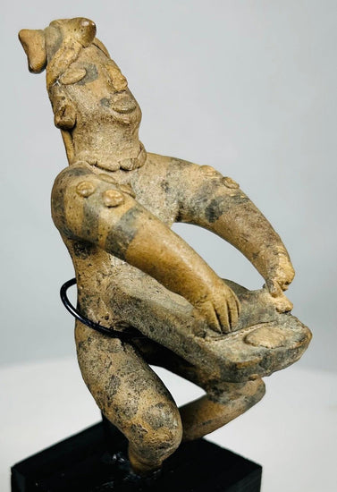 Close-up of ancient Pre-Columbian terracotta figure with earthen deposits