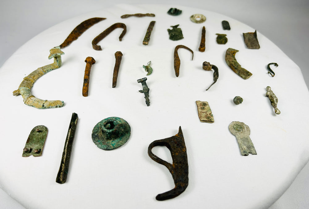 Collection of 28 authentic ancient Roman bronze artifact fragments from 1st to 12th century AD, including amulets, handles, tools, buttons, and decorative fittings displayed together
