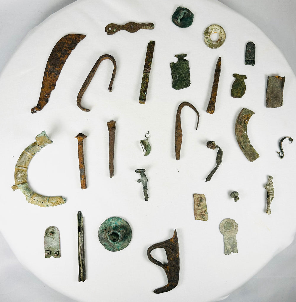 Close-up view of ancient Roman bronze relics showcasing patina, craftsmanship, and varied forms representing daily life and ritual objects of the Roman Empire.