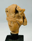 Close-up of Hellenistic to Greco-Roman terracotta head fragment showing naturalistic facial features and preserved surface texture.