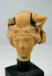 Detailed view of Mediterranean terracotta head fragment emphasizing sculptural artistry and fine facial modelled features.