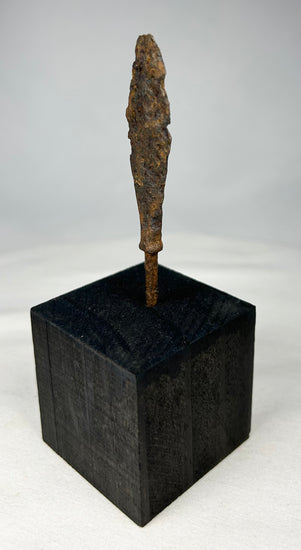 Side profile of ancient European iron weapon point displayed vertically