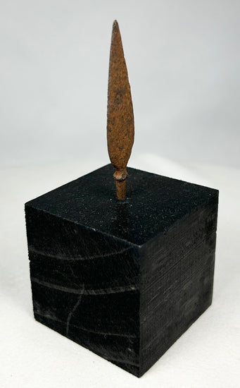 Authentic ancient iron projectile point showing aged patina and archaeological surface texture