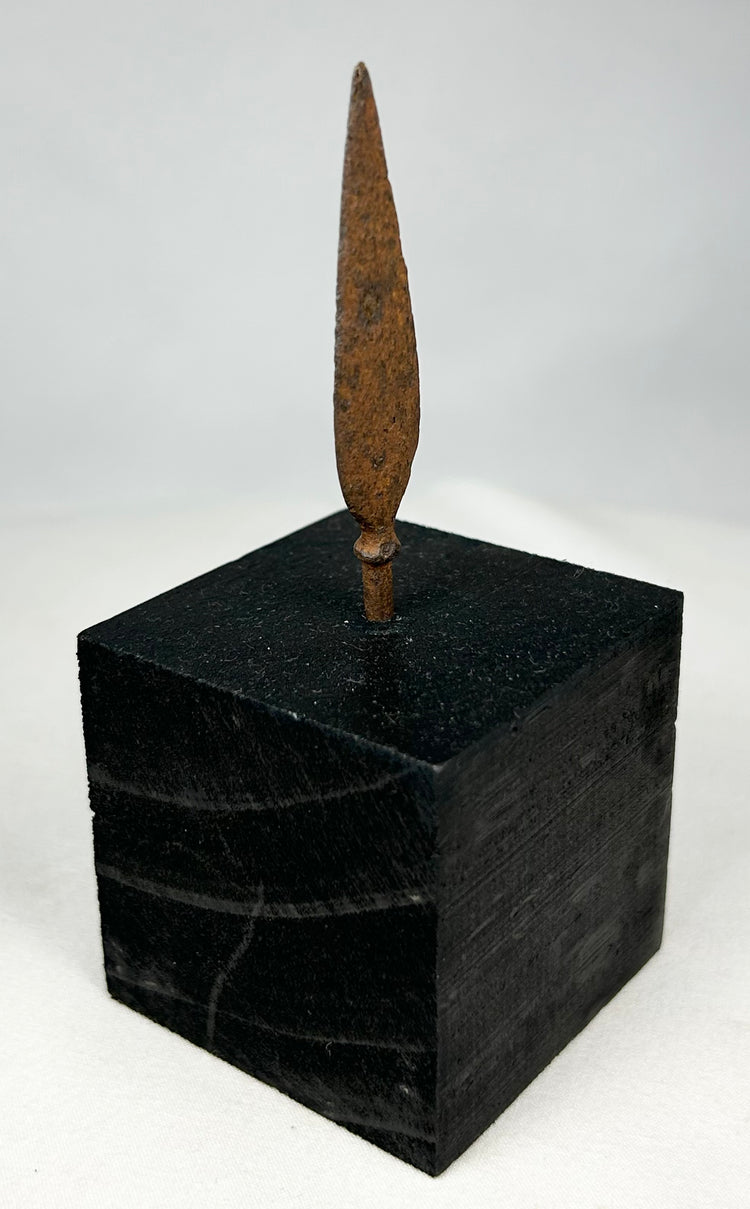Authentic ancient iron projectile point showing aged patina and archaeological surface texture