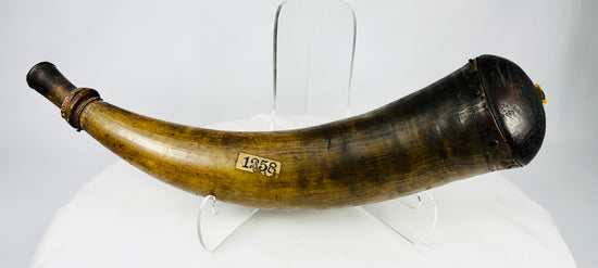 Antique powder horn with curved natural horn body, turned wooden stopper, and aged patina.
